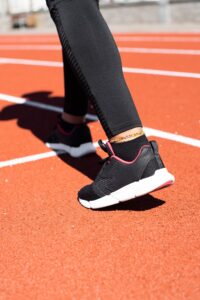 Primer plano de pies con zapatillas en una pista de atletismo, ilustrando el tipo de pisada
