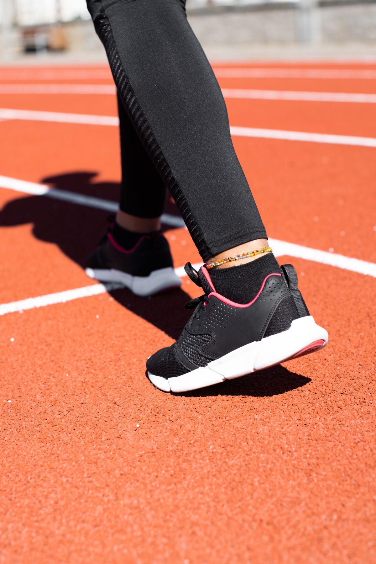 Primer plano de pies con zapatillas en una pista de atletismo, ilustrando el tipo de pisada